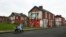 FILE - A woman pushes a stroller along a semi-derelict street in the Gresham area of Middlesbrough, northern Britain, Jan. 20, 2016. Asylum seekers in the northern English town of Middlesbrough are often suffering abuse.