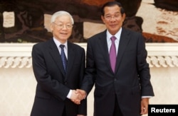 លោកប្រធានាធិបតីវៀតណាម ង្វៀន ហ៊្វូជុង (Nguyen Phu Trong) (ឆ្វេង) ចាប់ដៃស្វាគមន៍ជាមួយលោកនាយករដ្ឋមន្ត្រីកម្ពុជា ហ៊ុន សែន ខណៈ​ដែលលោកបានមកចូលរួមកិច្ចប្រជុំមួយ នៅរាជធានីភ្នំពេញ ថ្ងៃទី២៦ ខែកុម្ភៈ ឆ្នាំ២០១៩។