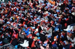 Spectators wave flags during the FIS Ski Cross World Cup 2022, part of a 2022 Beijing Winter Olympic Games test event at Genting Snow Park in Chongli county, Zhangjiakou city, China's Hebei province, Nov. 27, 2021.