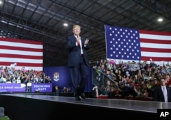 President Donald Trump walks toward the podium to speak at a rally at Total Sports Park, April 28, 2018, in Washington, Mich.