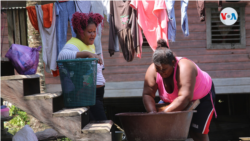Dos mujeres lavan la poca ropa que les quedó tras el paso del huracán Eta por Nicaragua. Foto Houston Castillo, VOA.