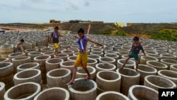 រូបឯកសារ៖ ក្មេងៗកំពុងឈរលេងលើបំពង់លូ។ 