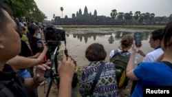 អ្នក​ទេសចរណ៍​ប្រមូល​ផ្តុំ​គ្នា​​​ដើម្បី​ថត​រូប​ប្រាសាទ​អង្គរវត្ត​ដ៏​ល្បីល្បាញ​របស់​កម្ពុជា​ក្នុង​អំឡុង​ពេល​ថ្ងៃ​រះ​នៅ​ខេត្ត​សៀមរាប​កាល​ពី​ថ្ងៃ​ទី​២០ ខែ​មីនា ឆ្នាំ​២០១៥។