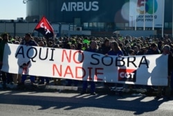 FILE - Airbus employees hold a banner reading "Everybody is useful" during a demonstration against layoffs outside Airbus' offices in Getafe, near Madrid, Feb. 21, 2020.