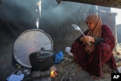 Yasmin Eid cooks at her family's tent in a refugee camp in Deir al-Balah, Gaza Strip, Nov. 19, 2024.