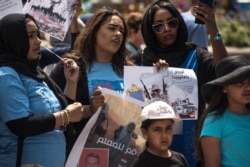 Protesters hold signs and sing at a rally in support of the Sudan's revolution, in Chicago, Illinois, June 29, 2019. (J. Patinkin/VOA)