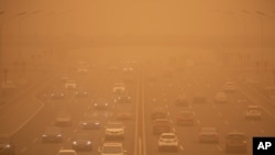 Vehículos en una autopista de Beijing a la hora pico de tráfico, el lunes 15 de marzo de 2021, en medio de una tormenta de arena.