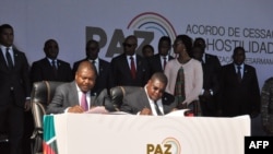 Presidente de Moçambique, Filipe Nyusi, (esq) e presidente da Renamo, Ossufo Momade (dir), assinam cessar-fogo, na Gorongosa, 1 de Agosto de 2019