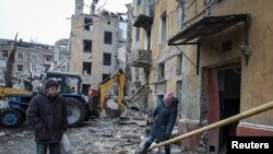 Residents are seen near a building destroyed by a Russian missile strike in Kramatorsk, Ukraine February 2, 2023. (Vyacheslav Madiyevskyy/Reuters)