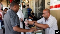 مردی در یک صرافی خیابانی در کربلا مشغول مبادله پول است (آرشیو)