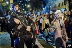 Heavily armed police guard as revelers march during the Greenwich Village Halloween Parade in New York, Oct. 31, 2017.