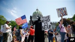 FILE - In this May 15, 2020, photo, protesters hold a rally against Pennsylvania's coronavirus stay-at-home order at the state Capitol in Harrisburg, Pa. 