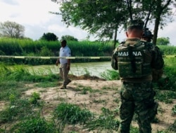Mexican authorities walk along the Rio Grande bank where the bodies of Salvadoran migrant Oscar Alberto Martínez Ramírez and his nearly 2-year-old daughter Valeria were found, in Matamoros, Mexico, June 24, 2019.