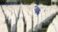 Bosnia and Herzegovina, A woman walks among graves in Memorial Center Potocari, near Srebrenica