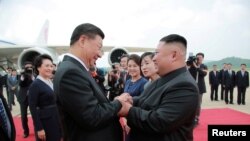 North Korean leader Kim Jong Un welcomes Chinese President Xi Jinping at the Pyongyang International Airport in Pyongyang, North Korea, in this undated photo released June 21, 2019 by North Korea's Korean Central News Agency.