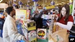 Rashad Allen, left, and Jameson Cole, check out with Jordanne Hambrick, right, after shopping at the Toy "R" Us in North Riverside, Ill., Friday, Nov. 28, 2008. (AP Photo\Charles Rex Arbogast)