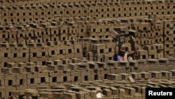 A laborer carries bricks at a kiln in Karjat, India, March 10, 2016. Thousands of brick kiln workers in India's western Maharashtra state are learning from activists that they have the right to a minimum wage, basic amenities and fair treatment - but rema