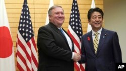 U.S. Secretary of State Mike Pompeo, left, shakes hands with Japanese Prime Minister Shinzo Abe at Abe's office in Tokyo, Oct. 6, 2018.