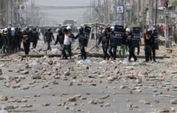 រូបឯកសារ៖ កម្មករ​ត្រូវ​បាន​ចាប់ឃុំ​ខ្លួន​ដោយ​នគរបាល​បង្ក្រាប​កុបកម្ម ក្រោយពី​មាន​ការប៉ះទង្គិច​គ្នា​នៅក្នុង​បាតុកម្ម​មួយ​ក្នុង​ទីក្រុង​ភ្នំពេញ នៅ​ថ្ងៃទី៣ ខែមករា ឆ្នាំ២០១៤។ (រូបថត៖ Reuters)