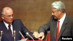 FILE - Boris Yeltsin and then Soviet President Mikhail Gorbachev touch hands during Gorbachev's address to the Extraordinary meeting of the Supreme Soviet of Russian Federation in Moscow, Aug. 23, 1991.