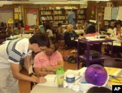 Graduate student Simon Pfeil demonstrates a bar model solution to fourth grade teacher Patricia Boyd.