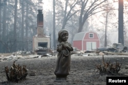 Una estatua delante de una casa destruida por el incendio Camp en Paradise, California. Nov. 17 de 2018.