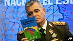 El ministro de defensa de Venezuela, general en jefe Vladimir Padrino López, lee un folleto sobre la soberanía de su nación en el Esequibo, durante una conferencia de prensa de voceros del gobierno de Nicolás Maduro en Caracas, en octubre de 2023.