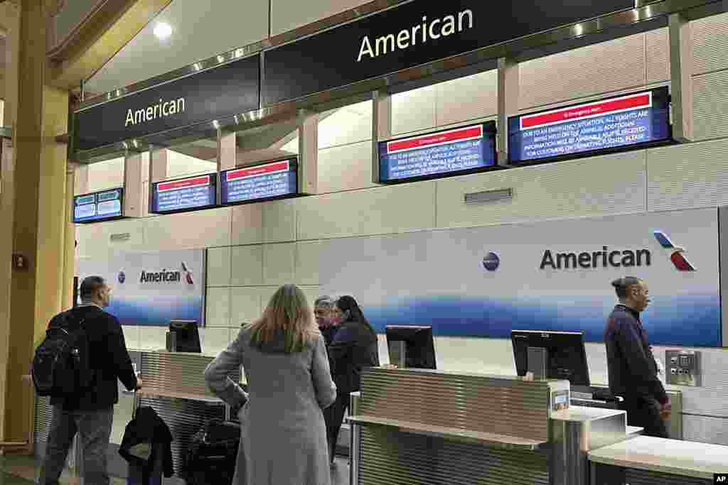 Signs display an "Emergency Alert" above an American Airlines counter in the terminal at Ronald Reagan Washington National Airport, Jan. 29, 2025, in Arlington.