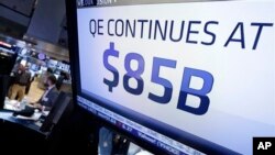 Una pantalla anuncia en Wall Street la decisión de la FED de seguir comprando bonos del Tesoro de EE.UU.