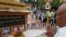 FILE - A man prays in front of portraits of victims of a fatal 1997 grenade attack on an opposition rally, which are displayed during a ceremony to remember the victims, at a monument in Phnom Penh, Cambodia, March 30, 2018. (Reuters)