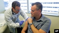 Farmaceut Majkl Vite daje injekciju Nilu Brauningu u Sijetlu, u okviru prve faze testiranja nove vakcine za coronavirus (Foto: AP/Ted S. Warren)