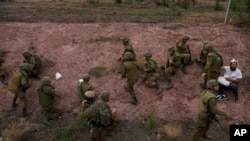 Izraelsi vojnici i civil kriju se dok se oglašavaju sirene zbog ispaljenih raketa iz Pojasa Gaze (Foto: AP Photo/Ohad Zwigenberg)