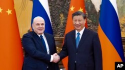Na ovoj fotografiji koju je objavila novinska agencija Xinhua, u posjeti ruski premijer Mihail Mišustin, lijevo, rukuje se s kineskim predsjednikom Xi Jinpingom prije njihovih razgovora u Pekingu 20. decembra 2023. godine.