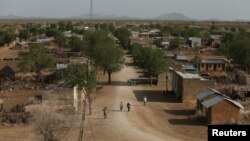 A member of the Taliban forces points his gun at protesters, as Afghan demonstrators shout slogans during an anti-Pakistan protest, near the Pakistan embassy in Kabul, Afghanistan.