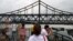 Chinese visitors look on from the Broken Bridge as a train travels on the Friendship Bridge across the Yalu river from North Korea to China, in Dandong, Liaoning province, China, June 10, 2018. 