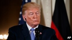 President Donald Trump listens to a question during a news conference with German Chancellor Angela Merkel in the East Room of the White House, April 27, 2018, in Washington. 