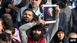 Čovek drži sliku ubijenog Kasema Sulejmanija tokom današnjih demonstracija u Teheranu (Foto: AFP/Atta Kenare)