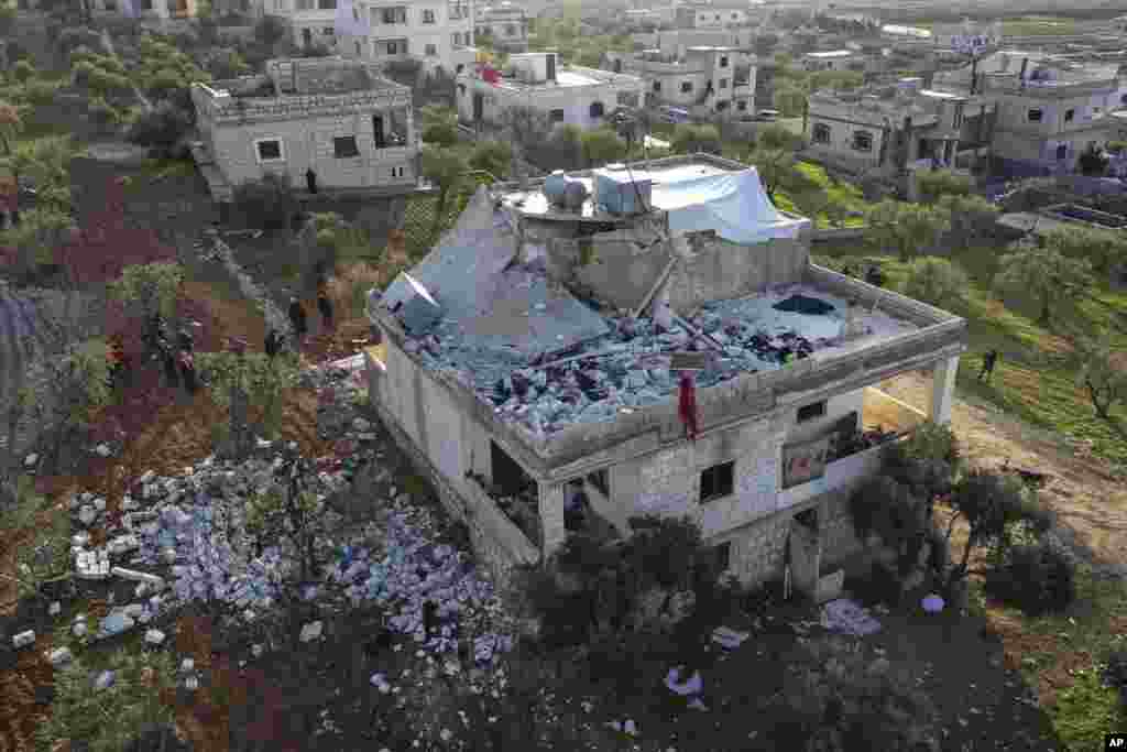 People inspect a destroyed house following an operation by the U.S. military in the Syrian village of Atmeh, in Idlib province, Syria. U.S. special operations forces conducted a large-scale counterterrorism raid in northwestern Syria. President Joe Biden said the leader of the Islamic State group has been killed in Syria during the operation.