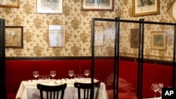 Plastic shields are placed between tables in the Alain Ducasse's restaurant, Allard, in Paris, June 11, 2020.