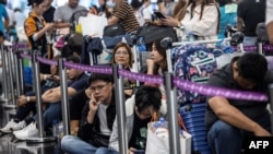 በሆንግ ኮንግ ዓለም አቀፍ አየር ማረፊያ የተጉላሉ ተጓዦች (ፎቶ ኤኤፍፒ 07/19/2024) 