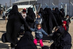 Women and children are seen in the Kurdish-run al-Hol camp which holds suspected relatives of Islamic State (IS) group fighters, in Hasakeh governorate in northeastern Syria, Jan. 28, 2021.