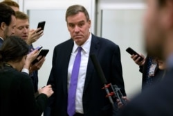 Sen. Mark Warner, D-Va., talks to reporters on Jan. 28, 2020, on Capitol Hill in Washington.