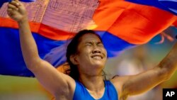 Cambodia's Chov Sotheara celebrates her victory over Thailand's Suree Porn Pimpak to win the gold medal in the women's under 44-kilogram wrestling match at South East Asian Games in Yangon, Myanmar, Friday, Dec 13, 2013. (AP Photo/Gemunu Amarasinghe)