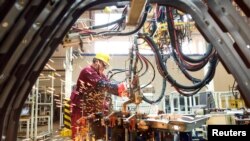 中國山東濰坊的江淮汽車製造廠的工人在生產線上（2020年2月28日）
