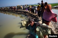 FILE - Rohingya refugees make their way to a refugee camp after crossing the Bangladesh-Myanmar border in Palong Khali, near Cox's Bazar, Bangladesh, Nov. 3, 2017.