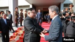South Korean President Moon Jae-in shakes hands with North Korean leader Kim Jong Un during their summit at the truce village of Panmunjom, North Korea, May 27, 2018.