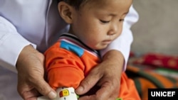 지난 2012년 6월 유니세프 직원이 북한 함경남도 함흥의 한 애육원(고아원)에서 남자 어린이의 팔둘레를 측정하고 있다. 당시 애육원에서 지내는 고아 300명 중 10%가 영양실조 상태인 것으로 파악됐다.