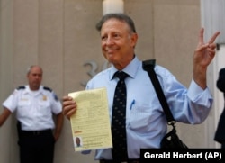 Dick Heller, who sued to overturn Washington handgun ban, poses for the media after picking up his gun registration, Monday, Aug. 18, 2008 at Washington's Metropolitan Police headquarters. (AP Photo/Gerald Herbert)