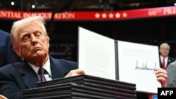 Trump mostra um dos decretos que assinou ontem