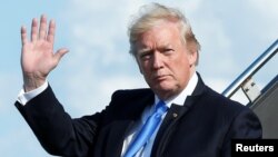 U.S. President Donald Trump waves as he arrives at Newark International airport in Newark, N.J., to spend a weekend at Trump National Golf Club in Bedminister, June 9, 2017. 